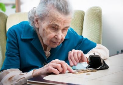 anziana che conta soldi della pensione