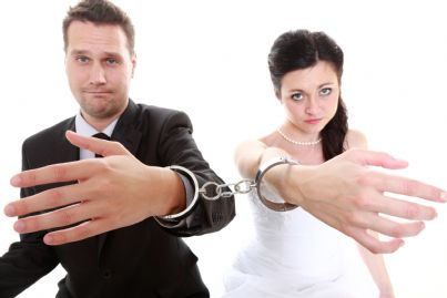 coppia di sposi con manette che chiede liberazione simbolo divorzio consensuale