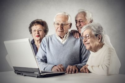 pensionati insieme davanti al computer