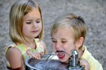 bambini che bevono acqua potabile da una fontana
