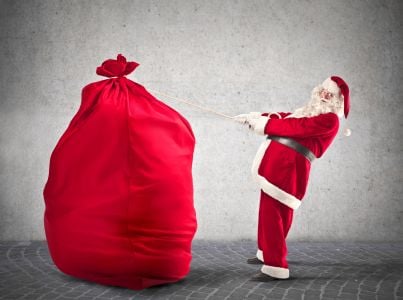 babbo natale che trasporta un grande sacco pieno di doni