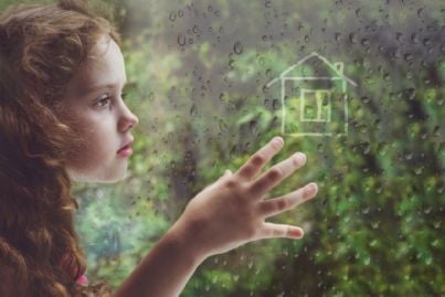bambina alla finestra sognando casa