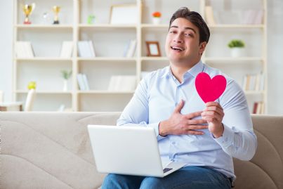 uomo innamorato con cuore in mano e computer